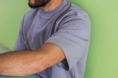 Şık, rahat bir spor giyim tarzında, parlak bir geçmişe sahip bir adam, dergi için stüdyo çekimi, kumaş ve çiçeklerle ilgili detaylar.