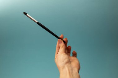Mavi arka planda makyaj fırçaları