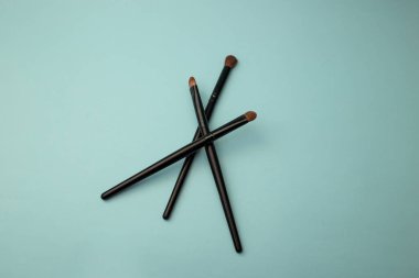 Mavi arka planda makyaj fırçaları