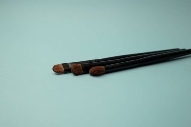 Mavi arka planda makyaj fırçaları