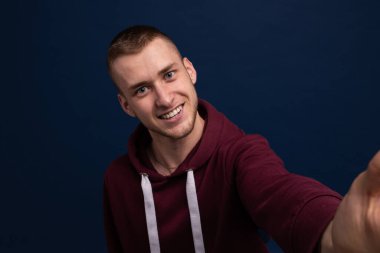 Kırmızı kapüşonlu bir gencin yakın çekimi ilk kişinin fotoğrafını çeker.