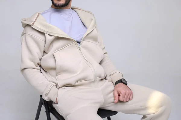 Şık, rahat bir spor giyim tarzında, parlak bir geçmişe sahip bir adam, dergi için stüdyo çekimi, kumaş ve çiçeklerle ilgili detaylar.