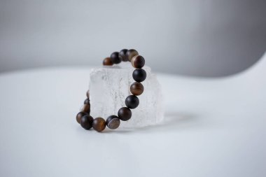 Çok renkli doğal taşların boncukları kar beyazı bir taşın üzerinde bulunur.