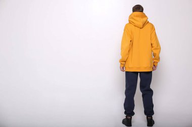 Şık, rahat bir spor giyim tarzında, parlak bir geçmişe sahip bir adam, dergi için stüdyo çekimi, kumaş ve çiçeklerle ilgili detaylar.