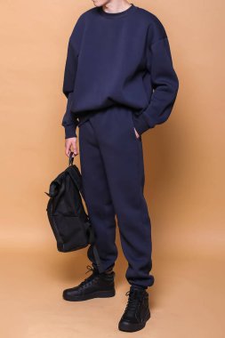 Şık, rahat bir spor giyim tarzında, parlak bir geçmişe sahip bir adam, dergi için stüdyo çekimi, kumaş ve çiçeklerle ilgili detaylar.