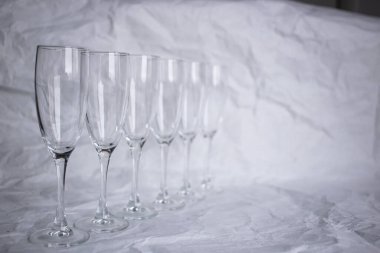 Beyaz arka planda ince camlı şarap kadehleri.