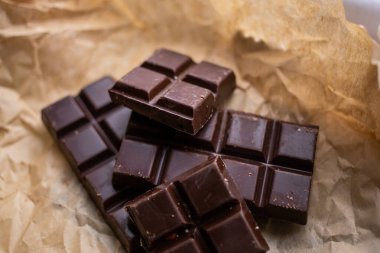 Kağıdın üzerinde bir kalıp siyah çikolata var.