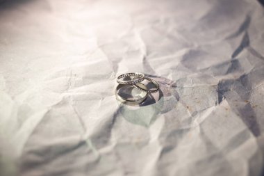 Yeni evlilerin alyansları beyaz altınla aynada duruyor.