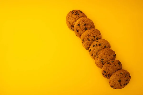 带有巧克力片的饼干的背景是黄色的 简约的 食物的 — 图库照片