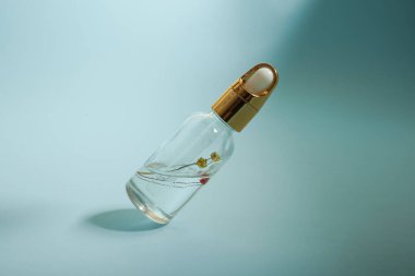 Bir şişe bakım kozmetiği, yağ, serum, arka planda ışığın altında duruyor, kadınlar için bir ürünün reklamını yapma kavramı.