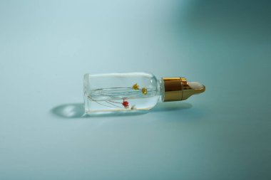 Bir şişe bakım kozmetiği, yağ, serum, arka planda ışığın altında duruyor, kadınlar için bir ürünün reklamını yapma kavramı.