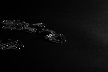 Metal ataçlar siyah arkaplanda yatar