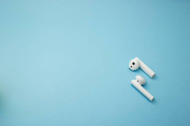 Parlak müzik kulaklıkları mavi bir arkaplanda.