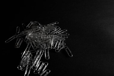 Metal ataçlar siyah arkaplanda yatar