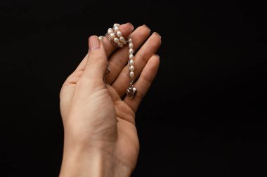 A girl holds in her hand a beautiful product made of silver and gold, a decoration accessory