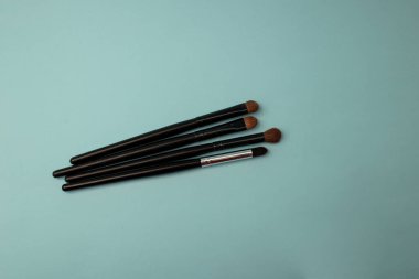 Mavi arka planda makyaj fırçaları