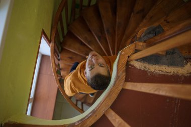 Turuncu elbiseli bir adam merdivenlerden yukarı çıkıyor.