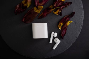 Arkaplanda parlak kablosuz kulaklıklar var.