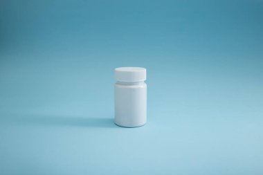 Mavi arka planda ilaç ambalajı, hastalığın tedavisi.