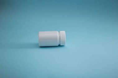 Mavi arka planda ilaç ambalajı, hastalığın tedavisi.