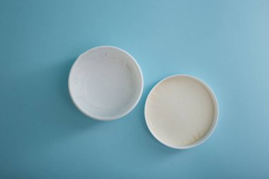 Mavi arka planda bir kavanoz krema, güzellik ve vücut bakımı endüstrisi