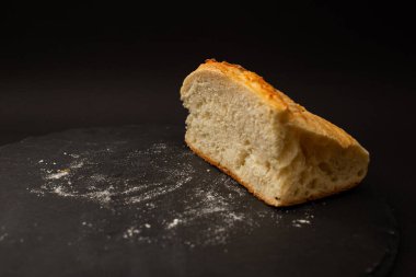 Siyah arkaplanda pişmiş beyaz ekmek.