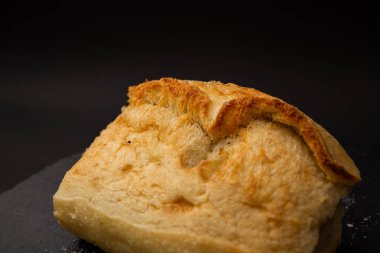Siyah arkaplanda pişmiş beyaz ekmek.