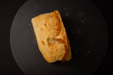 Siyah arkaplanda pişmiş beyaz ekmek.