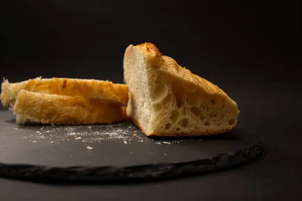 Siyah arkaplanda pişmiş beyaz ekmek.