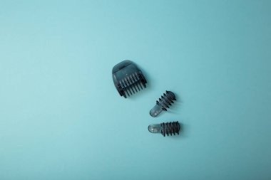 Mavi arkaplanda eklentileri olan elektrikli traş makinesi