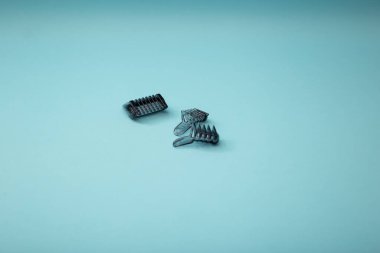 Mavi arkaplanda eklentileri olan elektrikli traş makinesi