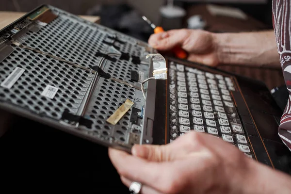 Guy repairs laptop at home