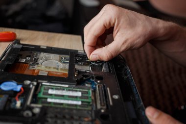 Adam dizüstü bilgisayarı tek başına tamir ediyor, bilgisayar tamir ediyor.