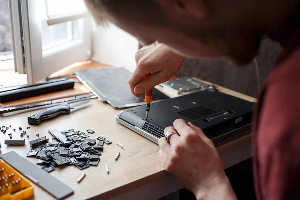 Man repairs laptop by himself, computer repair