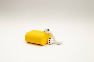 Parlak sarı çantalı kablosuz kulaklıklar.