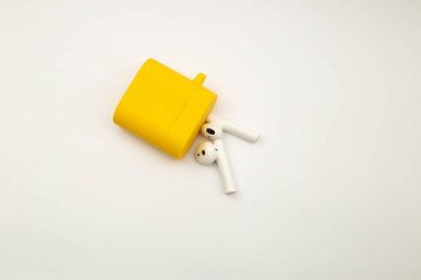 Parlak sarı çantalı kablosuz kulaklıklar.