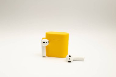 Parlak sarı çantalı kablosuz kulaklıklar.