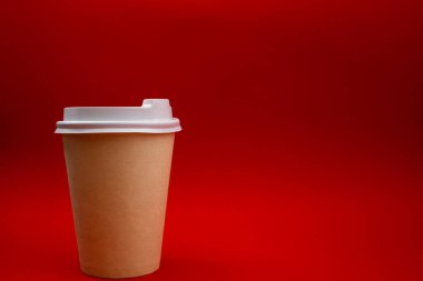 Kırmızı arka planda tek kullanımlık plastik bardak.