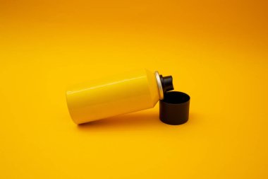 Sarı şişe sarı arka planda duruyor.