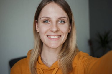 Bir kız kameraya gülümsüyor.