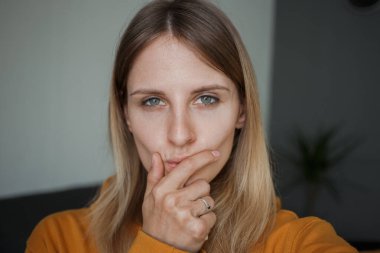 Kız ellerini yüzüne karşı nazikçe tutuyor.