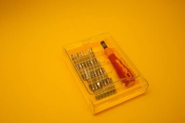 Parlak arkaplanda küçük parçaları olan tornavida