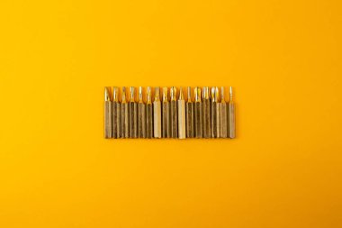 Small screwdriver bits on a yellow background