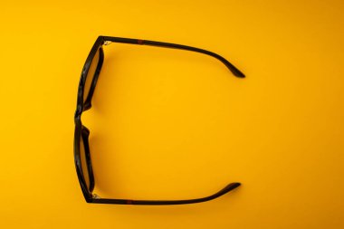 Turuncu arka planda siyah güneş gözlüğü