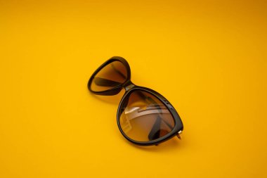 Black s sunglasses on orange background