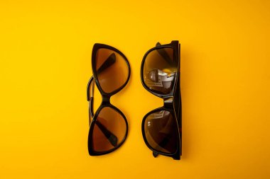 Turuncu arka planda siyah güneş gözlüğü