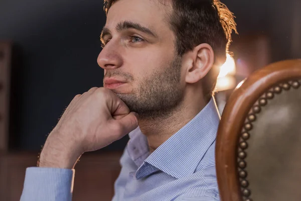 Gömlekli Gürcü bir adam eski bir sandalyede oturur.