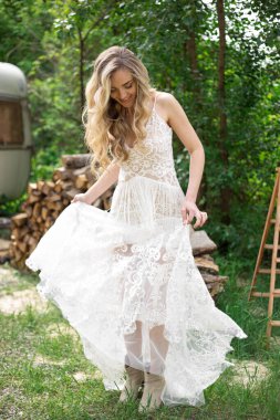 A bride on a ranch in a white dress and boots