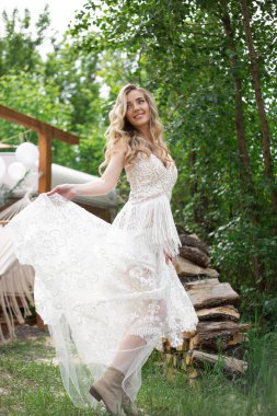 A bride on a ranch in a white dress and boots