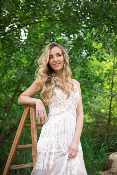 A bride on a ranch in a white dress and boots